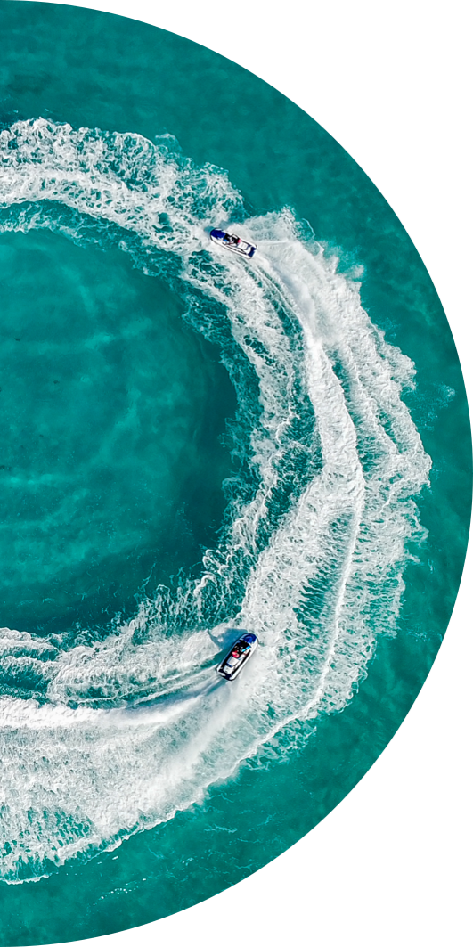 half circle image of an aerial view of jetski riders doing circles in the water
